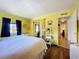 Bright bedroom with yellow walls, hardwood floors, and ample storage with mirrored closet at 1340 Elkhart Cir, Tavares, FL 32778