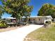 Charming single-story home with a well-maintained lawn, mature trees, and a paved driveway leading to the front entrance at 1340 Elkhart Cir, Tavares, FL 32778