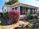 A sunny exterior of this home shows pink azaleas and a screened patio at 1340 Elkhart Cir, Tavares, FL 32778