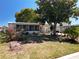 Charming single-story home with well-manicured lawn, mature trees, and colorful landscaping at 1340 Elkhart Cir, Tavares, FL 32778