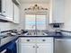 Bright kitchen with white cabinetry, black counters, and a large window for natural light at 1340 Elkhart Cir, Tavares, FL 32778