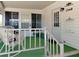 Inviting front porch with comfortable seating and a view of the well-maintained landscaping and charming white exterior at 1340 Elkhart Cir, Tavares, FL 32778