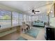 Bright sunroom with tiled floor, a ceiling fan, a glass table with chairs, and large windows that offer natural light at 1340 Elkhart Cir, Tavares, FL 32778