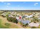 Expansive aerial view of the neighborhood with well-manicured lawns and mature trees, next to the golf course at 1380 Mayesville Way, The Villages, FL 32162