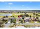 Beautiful aerial view of home in golf community, featuring lush landscaping and pond views at 1380 Mayesville Way, The Villages, FL 32162