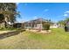 Backyard featuring an enclosed patio and lawn at 1380 Mayesville Way, The Villages, FL 32162