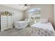 Bright bedroom with two twin beds, vaulted ceiling, and a large arched window at 1380 Mayesville Way, The Villages, FL 32162
