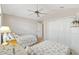 Cozy bedroom featuring two twin beds with matching seashell themed bedding, ceiling fan, and closet at 1380 Mayesville Way, The Villages, FL 32162