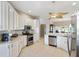 Modern kitchen featuring stainless steel appliances, white cabinets and a spacious layout at 1380 Mayesville Way, The Villages, FL 32162
