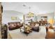 Bright living room featuring tile floors, brown leather couches, and a stone fireplace at 1380 Mayesville Way, The Villages, FL 32162