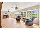 Bright living room featuring tile floors, two ceiling fans, golf course view, and comfortable furniture at 1380 Mayesville Way, The Villages, FL 32162