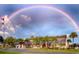 Beautiful building featuring tropical landscaping, under a rainbow on a partially cloudy day at 146 Jacaranda Dr, Leesburg, FL 34748