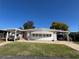 Charming single-story home with dual carports, manicured lawn, and light brick skirting at 146 Jacaranda Dr, Leesburg, FL 34748