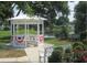 Relax in a quaint white gazebo overlooking the pond and beautiful landscaping at 146 Jacaranda Dr, Leesburg, FL 34748