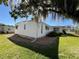 Well-maintained home exterior with vinyl siding, rock landscaping, and lush green lawn at 146 Jacaranda Dr, Leesburg, FL 34748