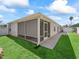 Back of the home showing a covered and screened patio with a well maintained lawn at 1487 Gantt St, The Villages, FL 32162