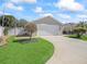 Charming single-story home features a well-manicured lawn and a two-car garage, enhancing its curb appeal at 1487 Gantt St, The Villages, FL 32162