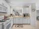Well-lit kitchen with white cabinetry, stainless steel appliances, and a view into an adjacent living space at 1487 Gantt St, The Villages, FL 32162