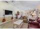 Spacious living area with a mounted TV, guitars, and a view of the adjacent dining and kitchen space at 1487 Gantt St, The Villages, FL 32162