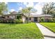 Charming single-story home with stone accents, manicured landscaping, and a welcoming front entrance with a walkway at 1494 Grace Lake Cir, Longwood, FL 32750