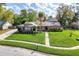 Beautifully landscaped front yard with lush green lawn and mature trees surrounding a well-maintained single-story home at 1494 Grace Lake Cir, Longwood, FL 32750