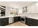 Modern kitchen featuring sleek black and white cabinetry, stainless steel appliances, and stylish gold hardware at 1494 Grace Lake Cir, Longwood, FL 32750
