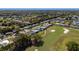 Eye-level view of homes alongside a meticulously maintained golf course, complemented by a beautiful tree line at 1510 E Schwartz Blvd, The Villages, FL 32159