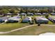 Aerial of homes within a lush golf course community, featuring well-kept lawns and trees at 1510 E Schwartz Blvd, The Villages, FL 32159