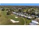Picturesque aerial shot showcasing residences bordering a well-manicured golf course, surrounded by mature trees at 1510 E Schwartz Blvd, The Villages, FL 32159