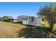 Exterior view of a well-maintained home with a white picket fence, a patio, and a lush green lawn at 1510 E Schwartz Blvd, The Villages, FL 32159