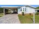 Well-maintained single story home featuring a paved driveway and open carport at 1510 E Schwartz Blvd, The Villages, FL 32159