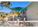 Inviting patio area featuring an umbrella-covered table, white railings, and a view of the golf course at 1510 E Schwartz Blvd, The Villages, FL 32159