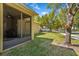 Backyard showing the screened-in lanai, grassy lawn, and mature trees at 15475 Camp Dubois Cres, Winter Garden, FL 34787