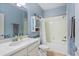 A light blue bathroom with mosaic tile accents, a shower-tub combo, and modern fixtures at 15475 Camp Dubois Cres, Winter Garden, FL 34787