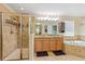 Bright bathroom featuring a double sink vanity, bathtub, and glass-enclosed shower at 15475 Camp Dubois Cres, Winter Garden, FL 34787