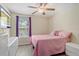 Cozy bedroom with a pink bed, bright window, and luxury vinyl flooring at 15475 Camp Dubois Cres, Winter Garden, FL 34787