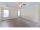 Spacious bedroom featuring wood-look floors, a modern ceiling fan, and large windows at 15475 Camp Dubois Cres, Winter Garden, FL 34787