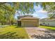 Exterior facade showcasing the lawn, paved driveway, and large garage at 15475 Camp Dubois Cres, Winter Garden, FL 34787