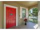 Close-up of a bright red front door, white trim, and a charming welcome sign at 15475 Camp Dubois Cres, Winter Garden, FL 34787