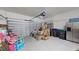 Cluttered two-car garage with boxes, bins, refrigerator and automatic door opener at 15475 Camp Dubois Cres, Winter Garden, FL 34787