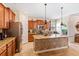 Spacious kitchen features wooden cabinets, a stone island, and stainless steel appliances at 15475 Camp Dubois Cres, Winter Garden, FL 34787