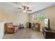 Cozy living room features wood-look floors, a ceiling fan, and a comfortable recliner at 15475 Camp Dubois Cres, Winter Garden, FL 34787