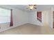 A bright living room with neutral tile flooring, ceiling fan, and stairway view at 15475 Camp Dubois Cres, Winter Garden, FL 34787