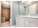Bathroom features a white vanity, updated mirror and a wood tiled shower with a modern design at 1638 Leesburg Blvd, Fruitland Park, FL 34731