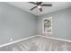 Bedroom features plush gray carpet, soft gray walls, ceiling fan and window letting in natural light at 1638 Leesburg Blvd, Fruitland Park, FL 34731