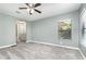 Bedroom with ceiling fan, plush gray carpet, soft gray walls and a glimpse into the bathroom at 1638 Leesburg Blvd, Fruitland Park, FL 34731