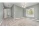 A dining room featuring a chandelier, soft gray walls, and plush gray carpeting at 1638 Leesburg Blvd, Fruitland Park, FL 34731