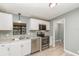 Modern kitchen features stainless steel appliances, gray walls and white cabinetry at 1638 Leesburg Blvd, Fruitland Park, FL 34731