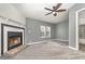 Cozy living room boasts a fireplace, ceiling fan, plush gray carpet and soft gray walls at 1638 Leesburg Blvd, Fruitland Park, FL 34731