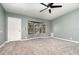 Well lit living room featuring neutral gray walls, large bay window, carpeted floor, and a ceiling fan at 1638 Leesburg Blvd, Fruitland Park, FL 34731